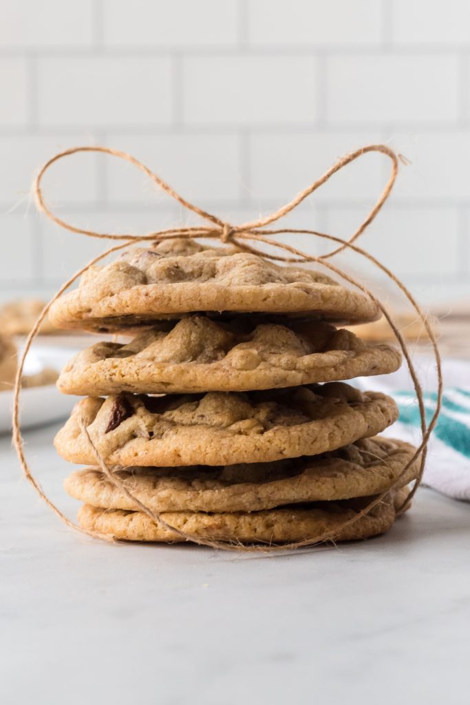 a stack of vegan chocolate chip cookies on a counter with a bow.