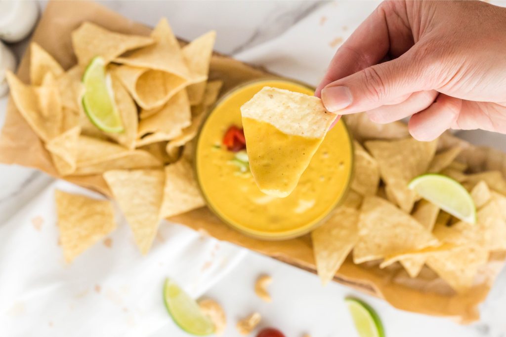 Close up of a chip with vegan queso on it.