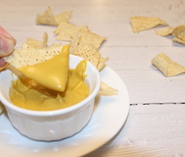 dipping chip in vegan queso recipe