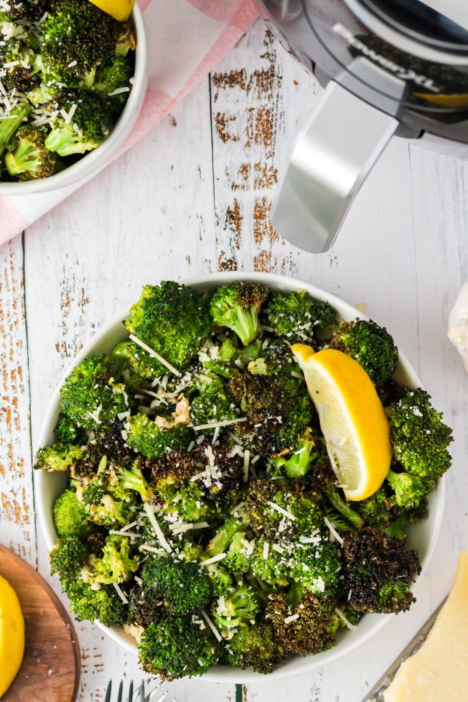 Air Fryer Broccoli in a bowl with a lemon slice.