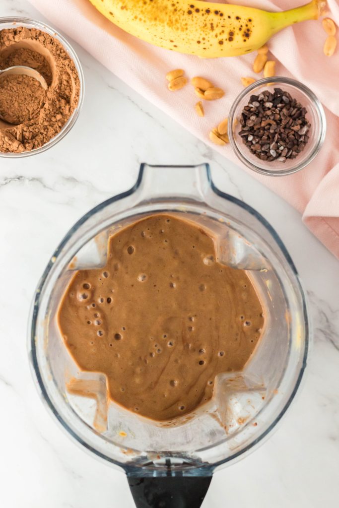 Blend chocolate peanut butter smoothie ingredients in a blender until smoothi.