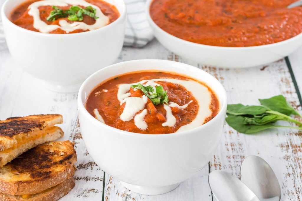 A bowl of vegan roasted tomato soup with cashew drizzle.