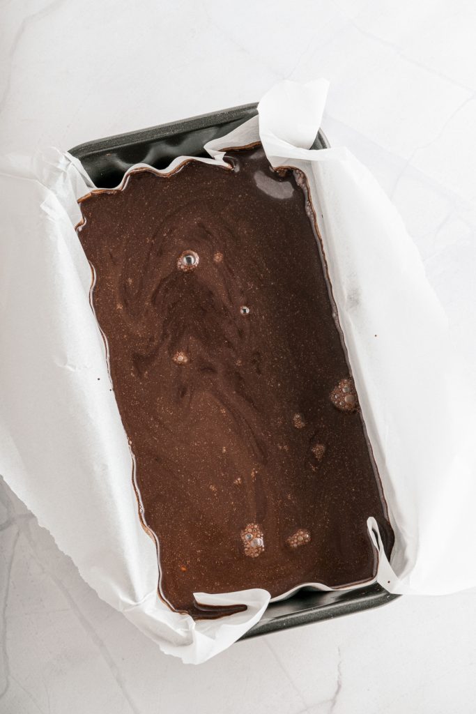 Vegan chocolate sorbet transferred to a parchment lined loaf pan ready to freeze.