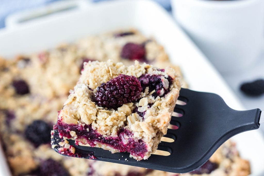 Close up image of a piece of the vegan blackberry oatmeal bars.