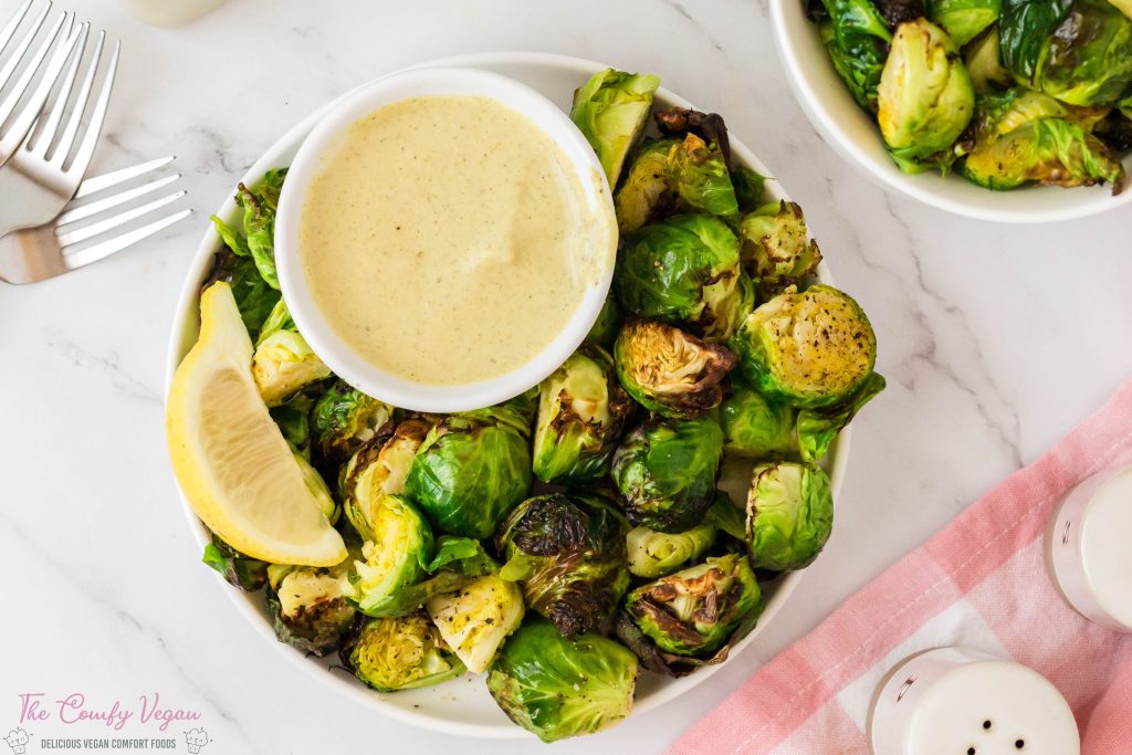 Vegan air fryer brussels sprouts with dipping sauce on the side.