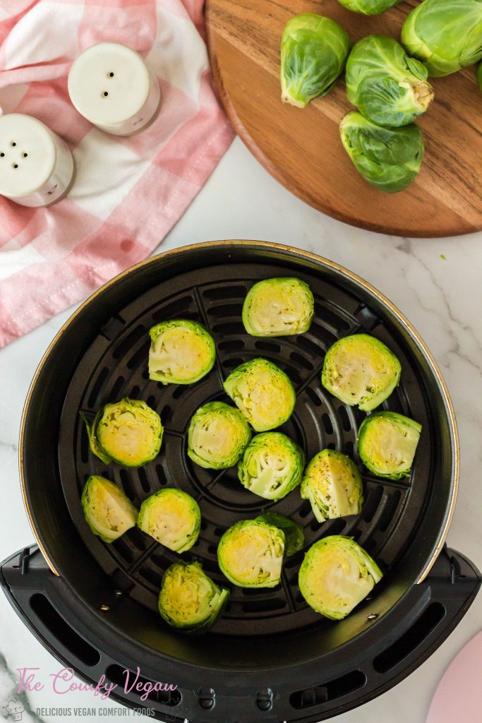 Brussels sprouts added to the air fryer basket.