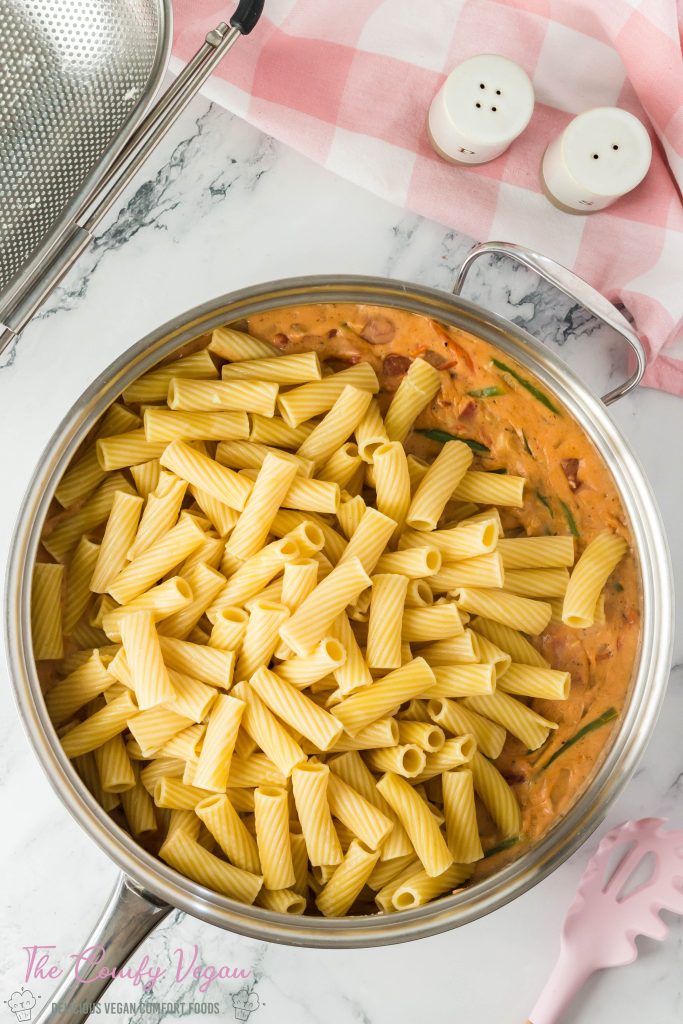 Add cooked pasta to the cajun pasta sauce.