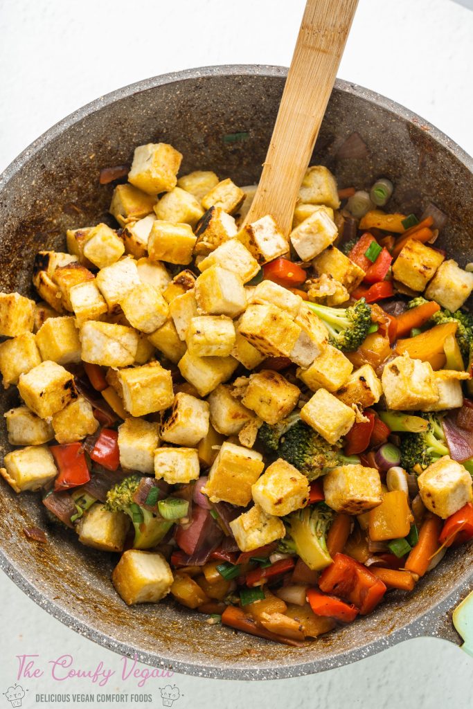 Tofu added to the wok of veggies.