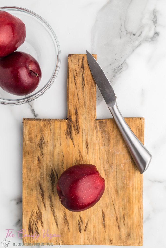 Apple on a cutting board with a knife.