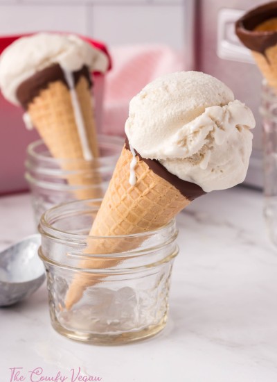 Vegan vanilla ice cream in a cone placed in a small jar so it can stand.