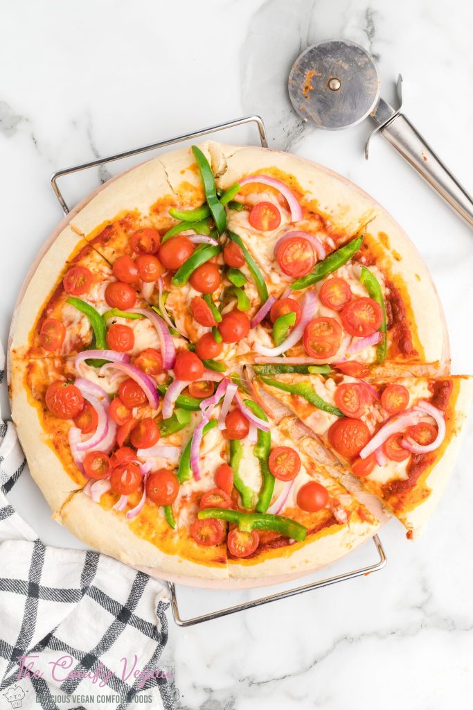 Vegan pizza on a pizza stone.